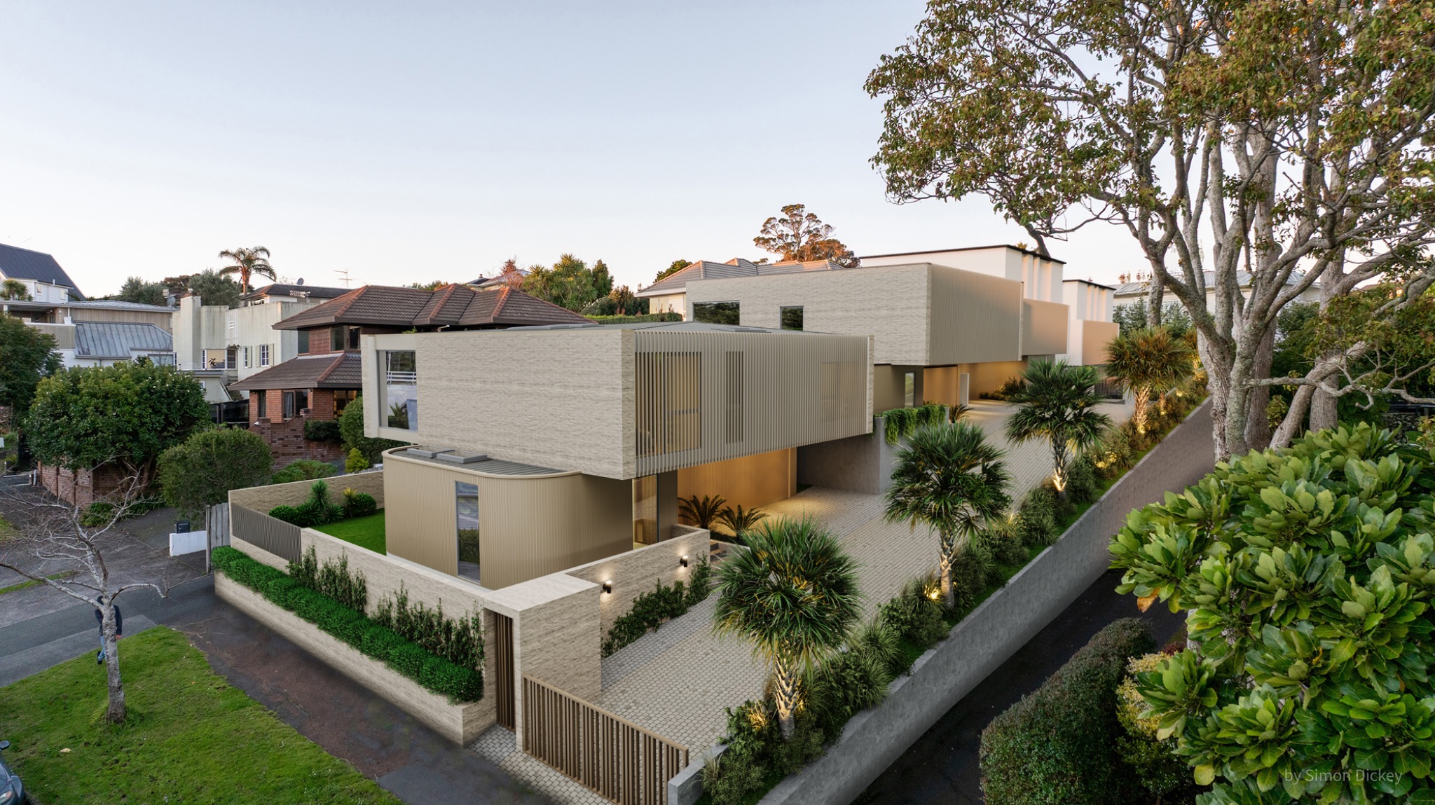 High-resolution residential development visualisation for 5 Clarendon Road, St Heliers, Auckland, showing contemporary multi-level homes arranged within an established neighbourhood, with refined masonry, metal screening, private entries and layered coastal planting. Photorealistic aerial exterior 3D render of contemporary residences at 5 Clarendon Road, St Heliers, Auckland, with pale masonry, metal screening and established coastal landscaping